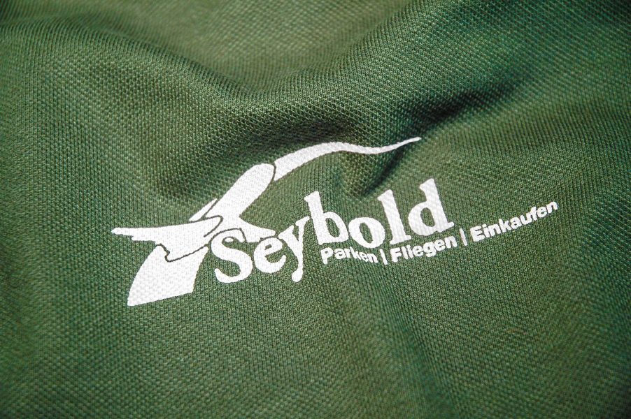 Die Werbeagentur Focus bietet unter anderem auch Textildrucke wie zb. auf Tshirt, Pullovers, Mützen, Jacken oder Schürzen an. Beispielsweiße hier für "Seybold"