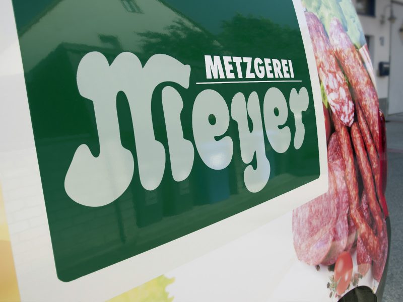 Detailaufnahme des gestochen scharfen digitalen Fotodrucks des Logos der Metzgerei Meyer für eine Fahrzeugbeklebung.