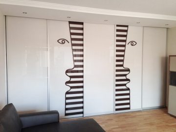Stilvolle Beklebung eines Glasschrankes für die Firma Schenk Wohnen in Nürnberg mit einem abstrakten Design zweier Personen.