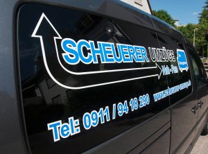 Nahaufnahme der Beklebung für das Auto von Scheuerer Umzüge in Blau, Schwarz und Weiß.