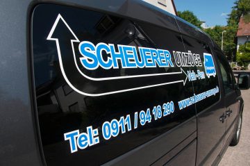 Nahaufnahme der Beklebung für das Auto von Scheuerer Umzüge in Blau, Schwarz und Weiß.