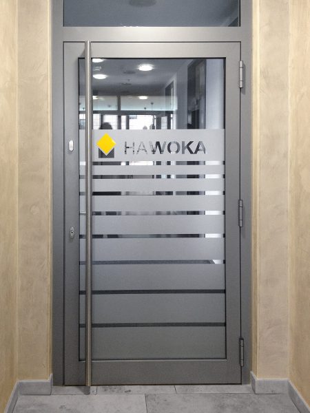 Durchlaufschutz aus Glasdekor an einer Eingangstüre, ergänzt mit Logo aus farbiger Folie