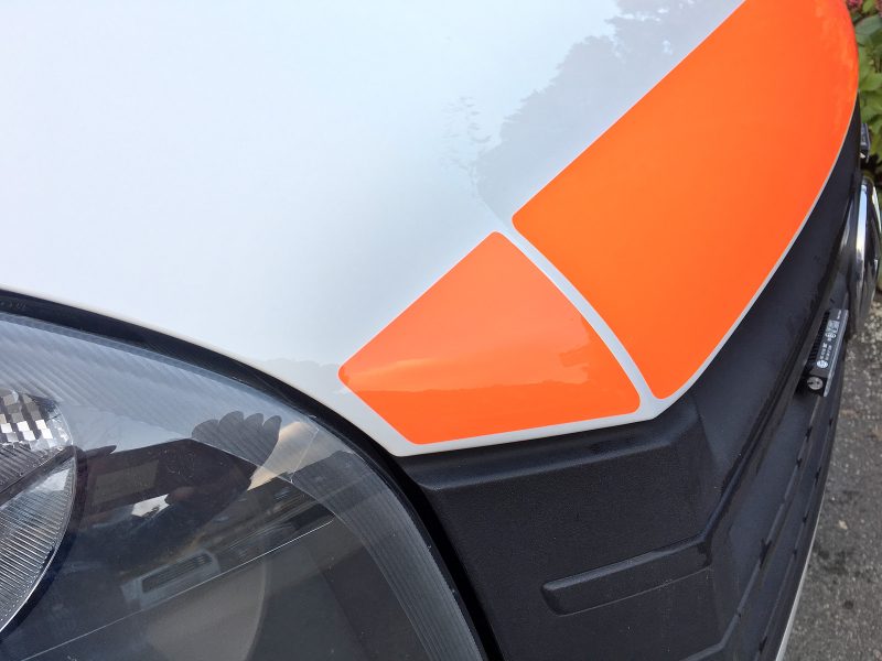 Detailansicht der orangenen Warnstreifenbeklebung eines Krankenwagens