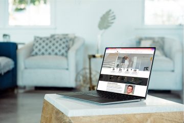 Die Webseite von Skimina Immobilien in einem Laptop an einem gemütlichen Wohnzimmerplatz sichtbar